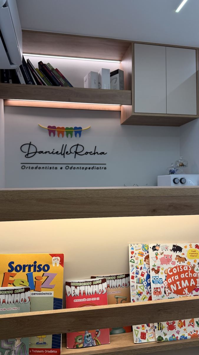 Recepção do consultório da Dra. Danielle Rocha, com livros infantis